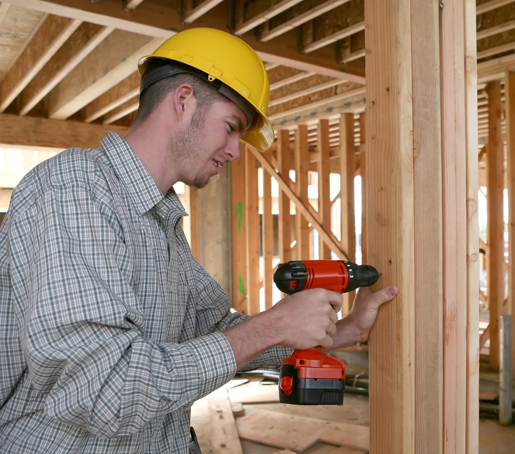 general contractor los angeles framing worker drilling wood structure construction project