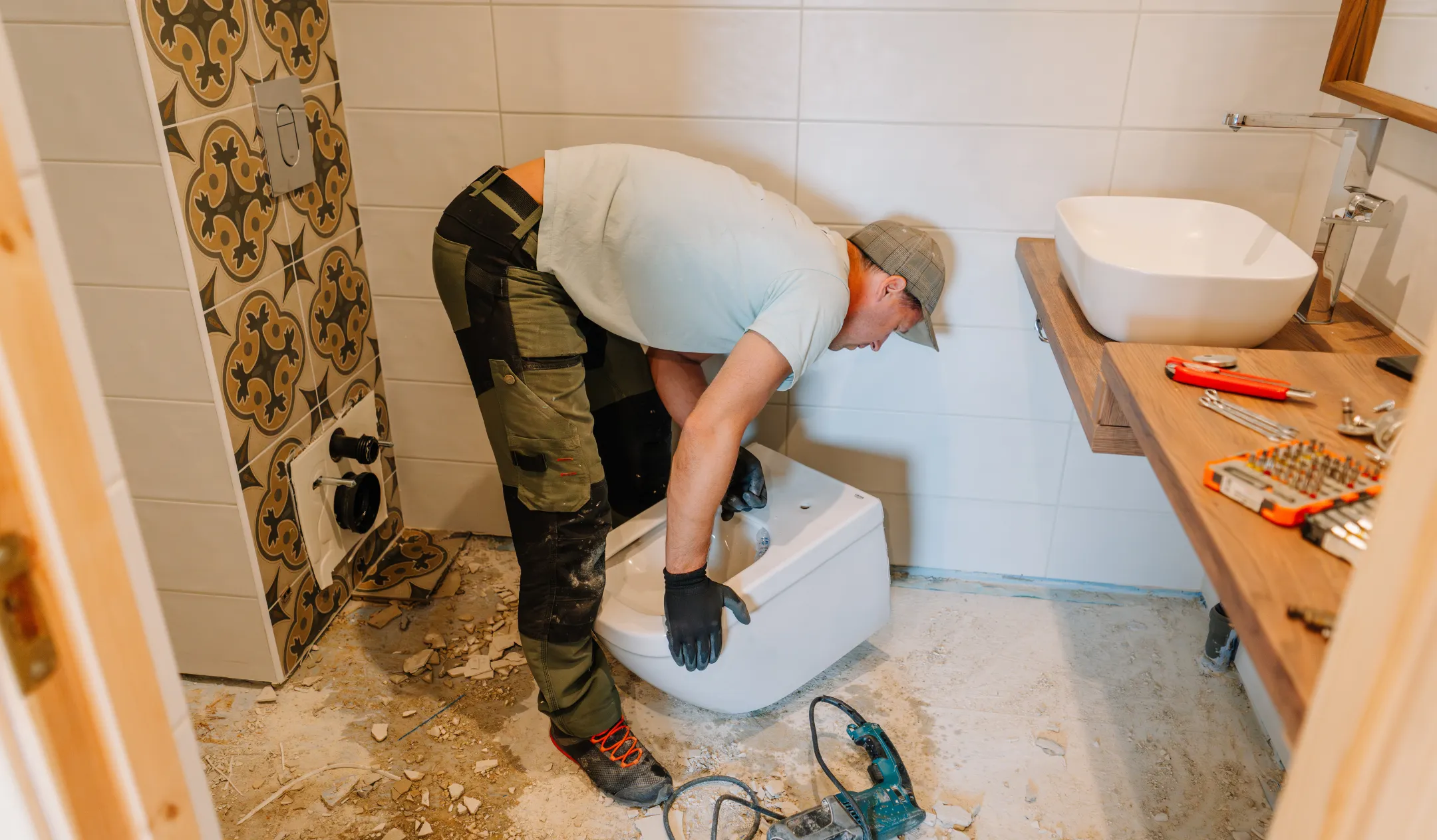 Bathroom remodeling project in Los Angeles with contractor installing modern toilet and finishing plumbing work in updated bathroom