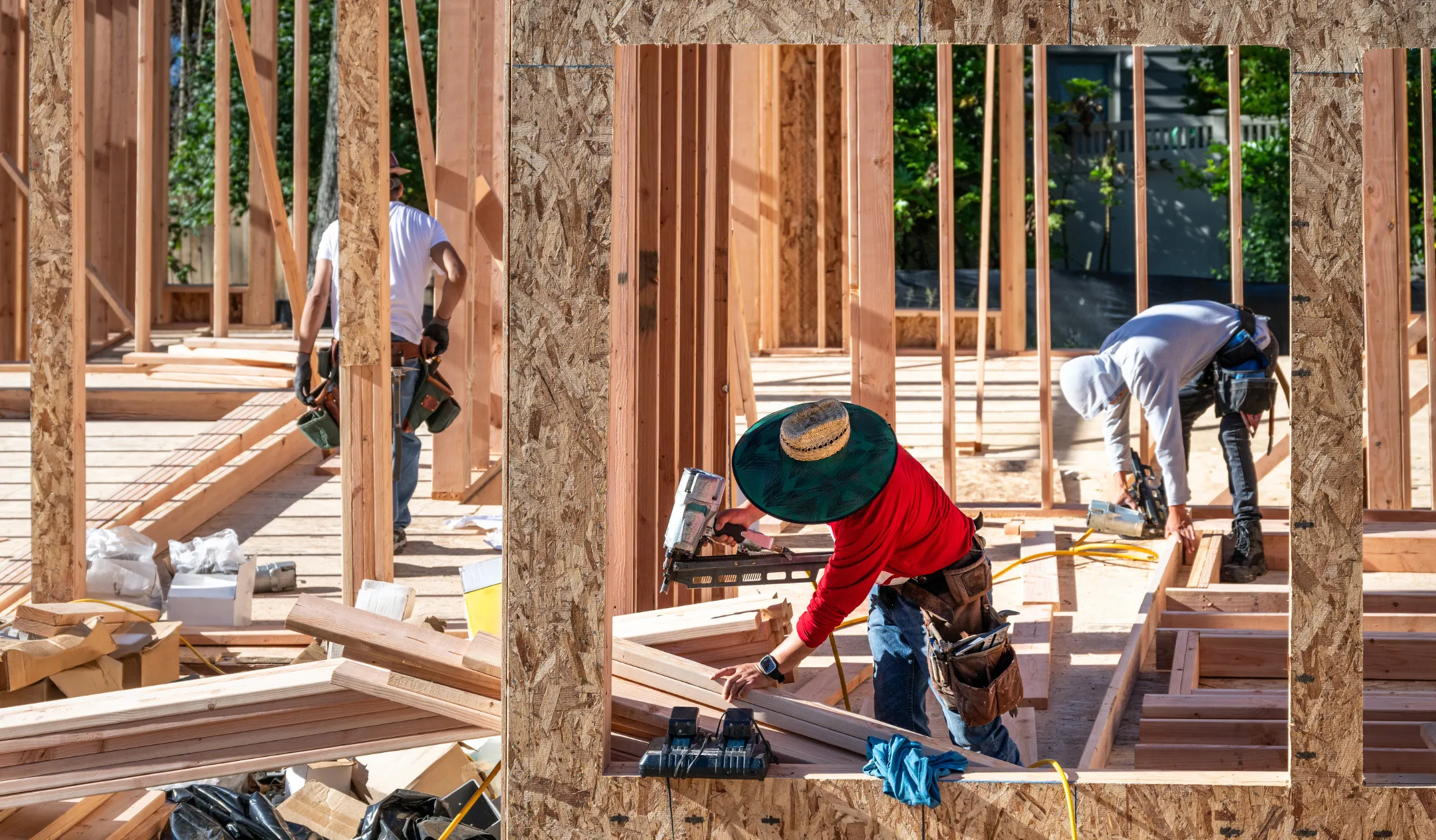 General contractor in Los Angeles managing residential framing construction project with crew installing wood structure on site
