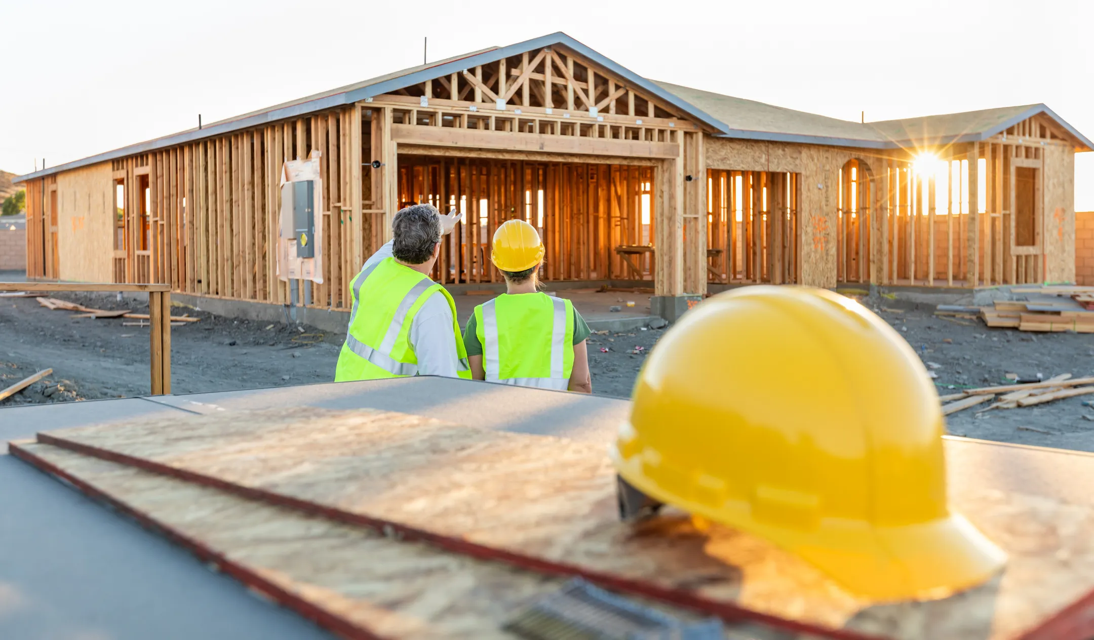 New home construction in Los Angeles showing ground-up residential house framing structure during early building phase at sunset