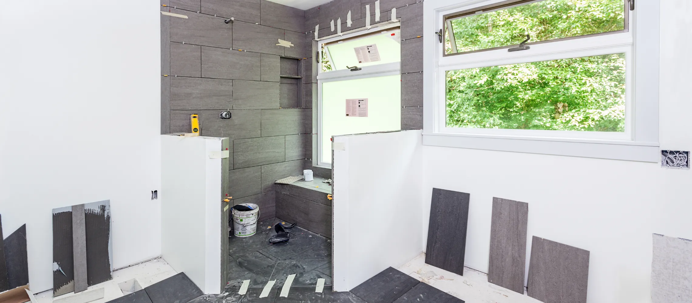 Bathroom remodeling site in Los Angeles with modern tile installation and layout renovation in progress with construction crew