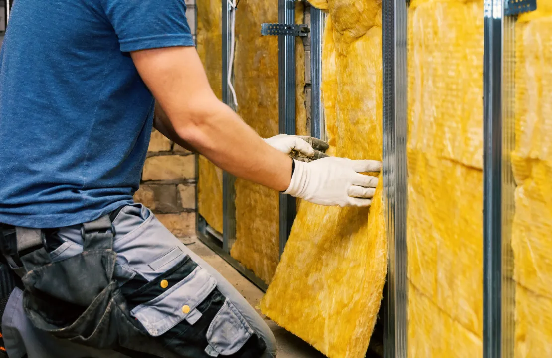 General contractor in Los Angeles installing wall insulation during residential framing construction